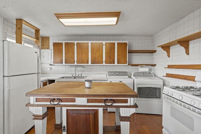 kitchen with washer and dryer, dark hardwood / wood-style floors, sink, backsplash, and white appliances