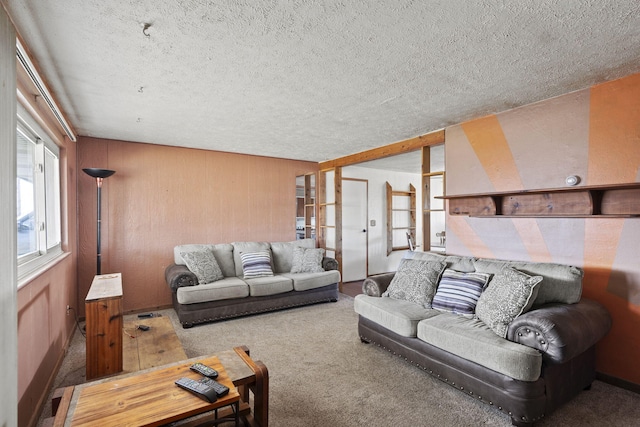 living room with carpet floors, a textured ceiling, and wood walls