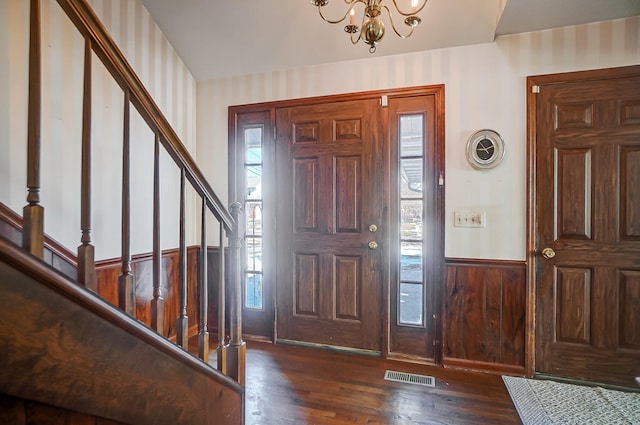 entrance foyer with plenty of natural light, dark hardwood / wood-style floors, and an inviting chandelier