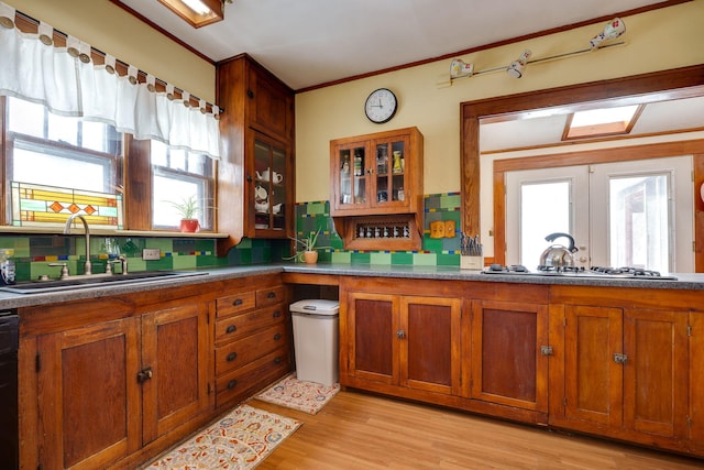 kitchen with stainless steel gas stovetop, sink, tasteful backsplash, and a healthy amount of sunlight