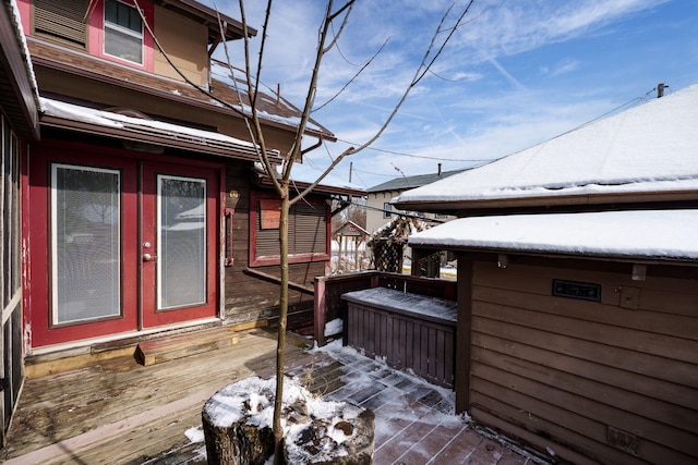 view of snowy exterior featuring a deck and french doors