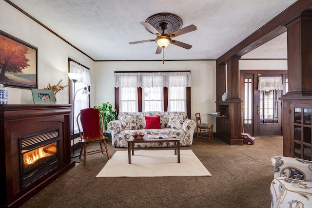 carpeted living room featuring crown molding, ornate columns, a textured ceiling, and ceiling fan