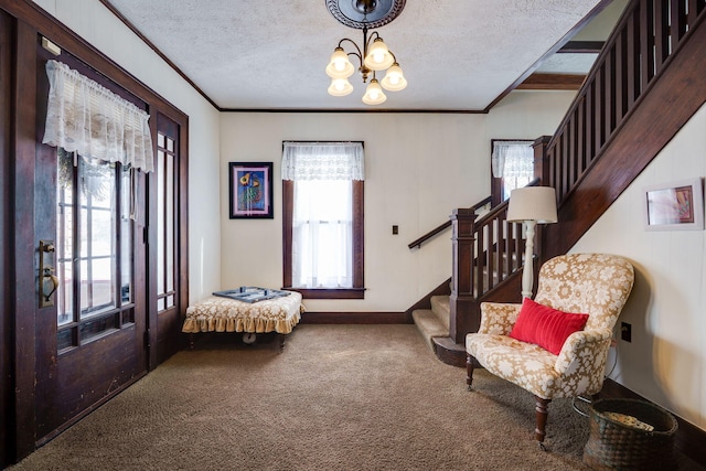 carpeted entrance foyer featuring a notable chandelier, crown molding, and a textured ceiling