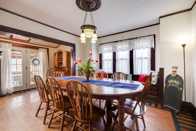 dining space with hardwood / wood-style floors, french doors, and ornamental molding