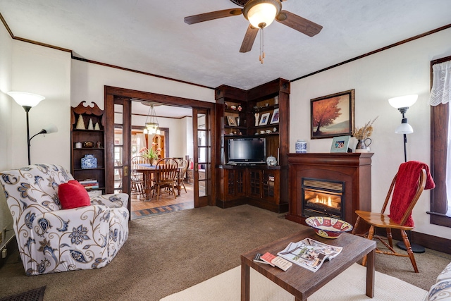 living room featuring carpet, crown molding, and ceiling fan