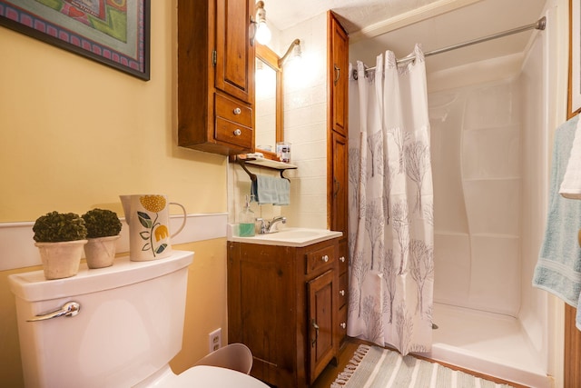 bathroom featuring toilet, vanity, and a shower with curtain