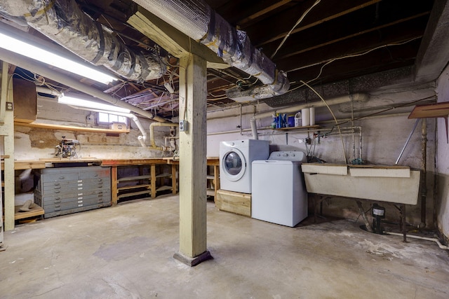 basement featuring washing machine and clothes dryer, sink, and a workshop area