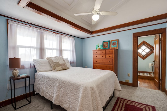 bedroom with ceiling fan, a raised ceiling, light carpet, ensuite bathroom, and ornamental molding