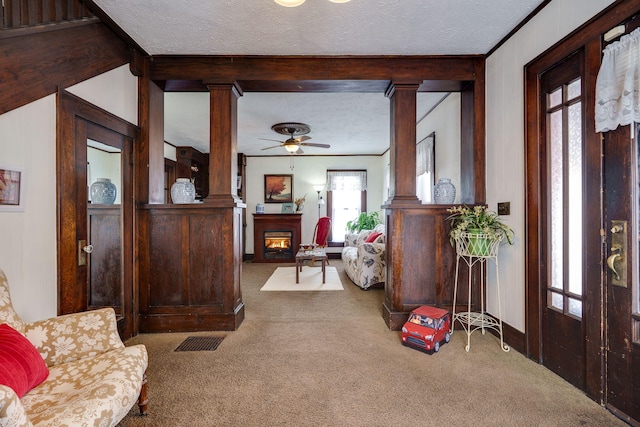 interior space featuring a healthy amount of sunlight, decorative columns, carpet floors, and a textured ceiling