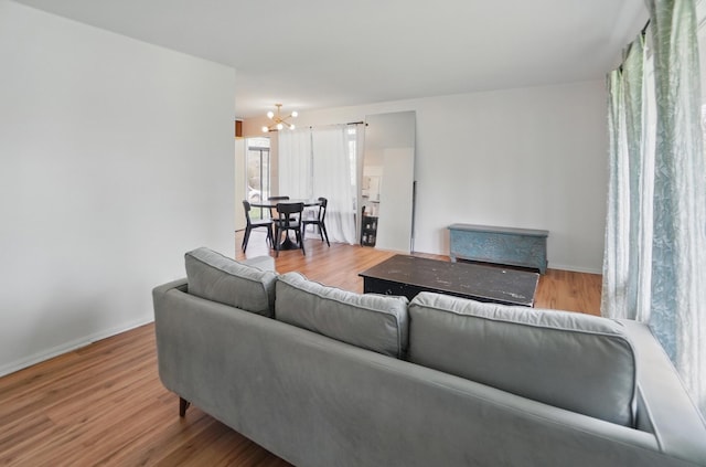 202 Fairfield Pike Unit A, Yellow Springs, OH 45387 - living area featuring baseboards, wood finished floors, and a notable chandelier