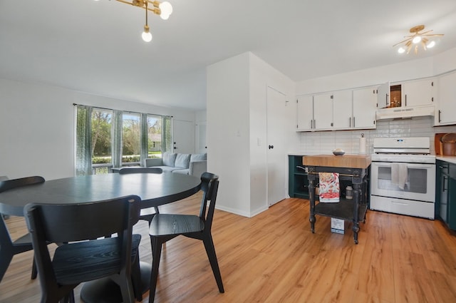 202 Fairfield Pike Unit A, Yellow Springs, OH 45387 - kitchen with white cabinets, light wood-style flooring, decorative backsplash, under cabinet range hood, and white range with gas cooktop