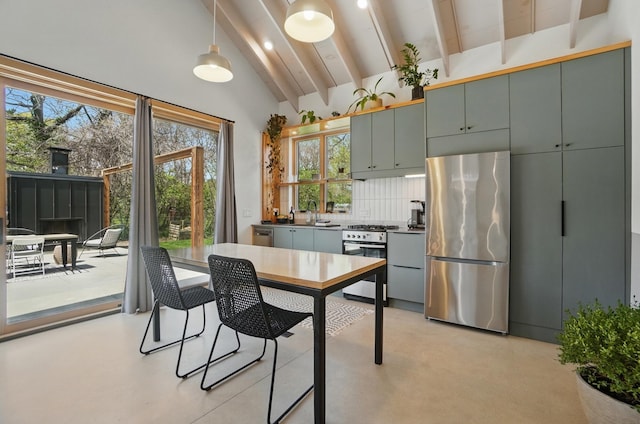 kitchen featuring backsplash, beamed ceiling, appliances with stainless steel finishes, and plenty of natural light