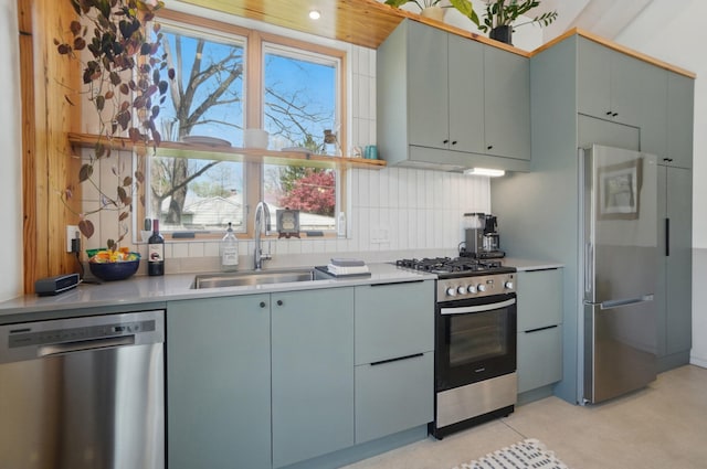 kitchen featuring light countertops, a sink, appliances with stainless steel finishes, and tasteful backsplash