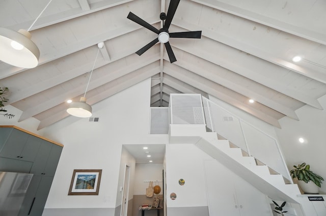 stairs featuring visible vents, beam ceiling, and high vaulted ceiling
