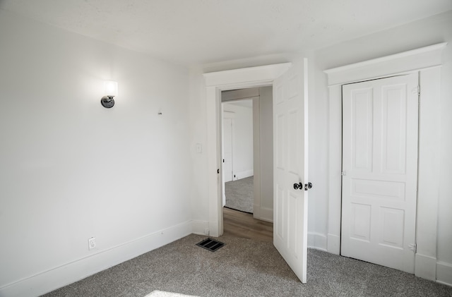 unfurnished bedroom with baseboards, a closet, visible vents, and carpet flooring