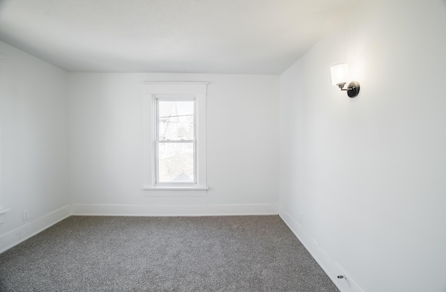 spare room featuring carpet and baseboards