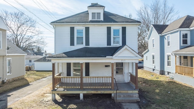 traditional style home with covered porch and a shingled roof