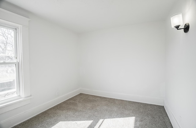 carpeted empty room featuring baseboards