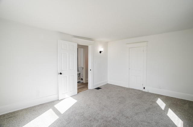 unfurnished room featuring carpet floors, baseboards, and visible vents