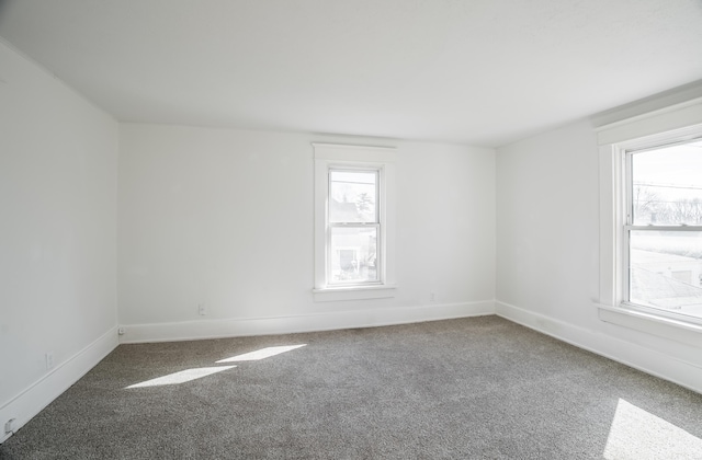 unfurnished room with carpet floors and baseboards