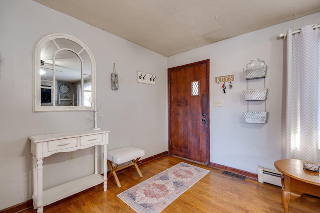 entrance foyer featuring baseboard heating and light hardwood / wood-style floors