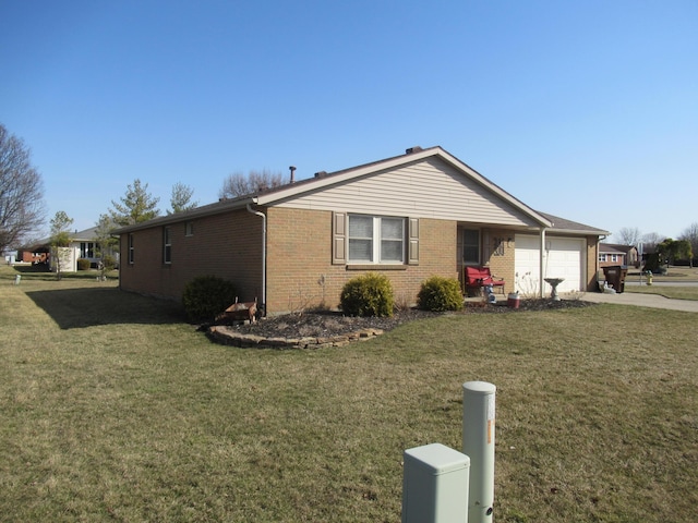 view of side of home with a yard, brick siding, concrete driveway, and an attached garage