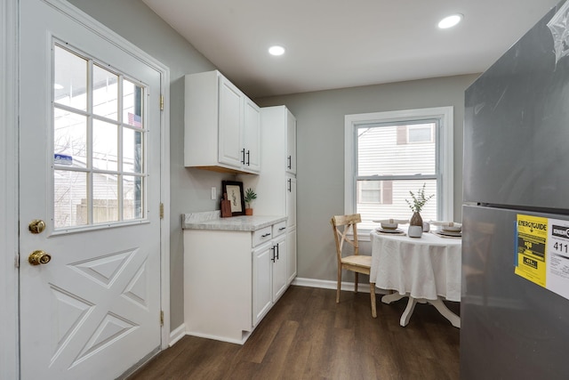 kitchen featuring a wealth of natural light, freestanding refrigerator, dark wood-style flooring, and white cabinetry