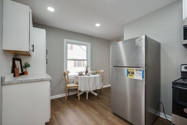 kitchen featuring recessed lighting, light countertops, appliances with stainless steel finishes, white cabinetry, and wood finished floors