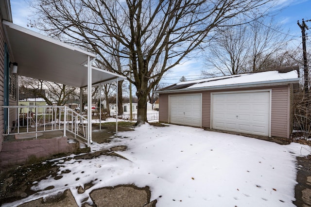 yard covered in snow with an outbuilding and a detached garage