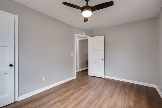 unfurnished room featuring ceiling fan, light wood-type flooring, and baseboards