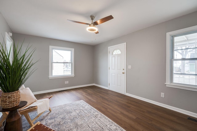 entryway with dark wood-style floors, baseboards, visible vents, and a ceiling fan