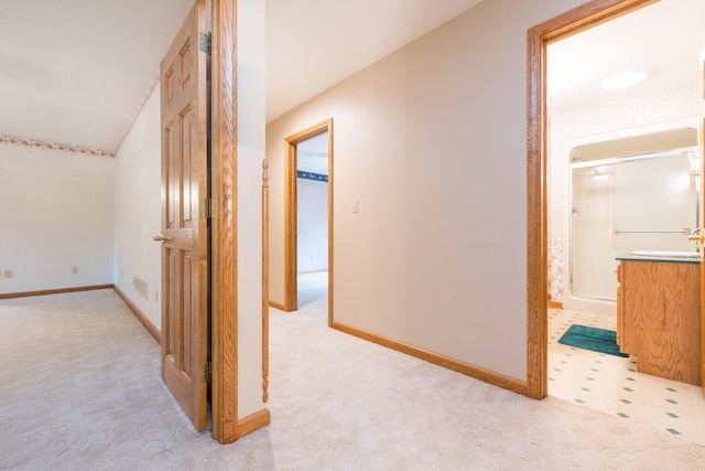 129 Tanglewood Dr, West Liberty, OH 43357 - hallway featuring light carpet, a sink, and baseboards