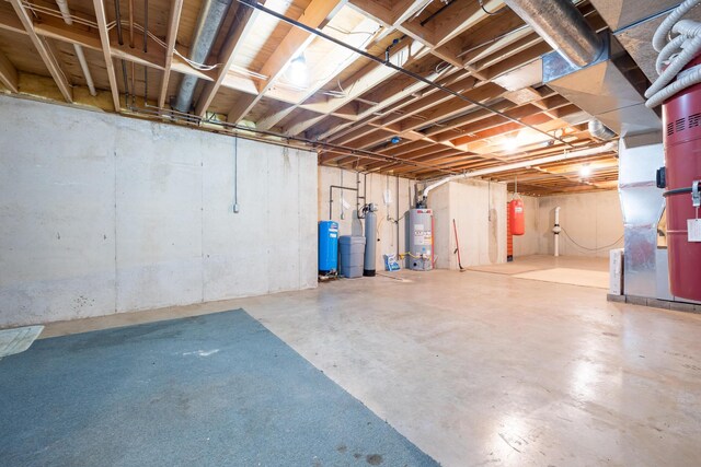 129 Tanglewood Dr, West Liberty, OH 43357 - unfinished basement featuring gas water heater, a water pressure tank, and a water softener system