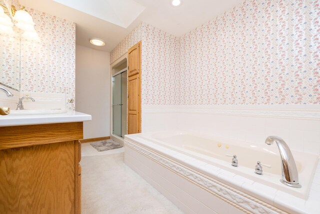 129 Tanglewood Dr, West Liberty, OH 43357 - bathroom with wallpapered walls, a wainscoted wall, vanity, a skylight, and a garden tub