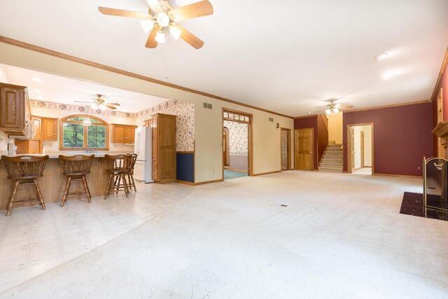 129 Tanglewood Dr, West Liberty, OH 43357 - living area featuring a ceiling fan, stairs, baseboards, ornamental molding, and a fireplace