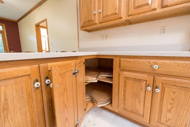 129 Tanglewood Dr, West Liberty, OH 43357 - kitchen view of crown molding, light flooring, light countertops, and brown cabinetry
