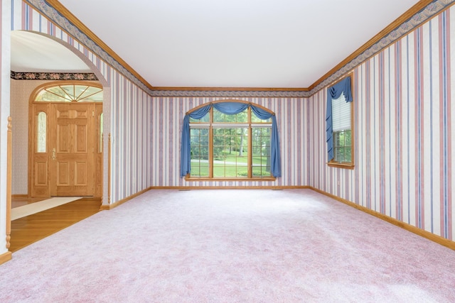 129 Tanglewood Dr, West Liberty, OH 43357 - carpeted empty room featuring wallpapered walls, arched walkways, crown molding, and baseboards