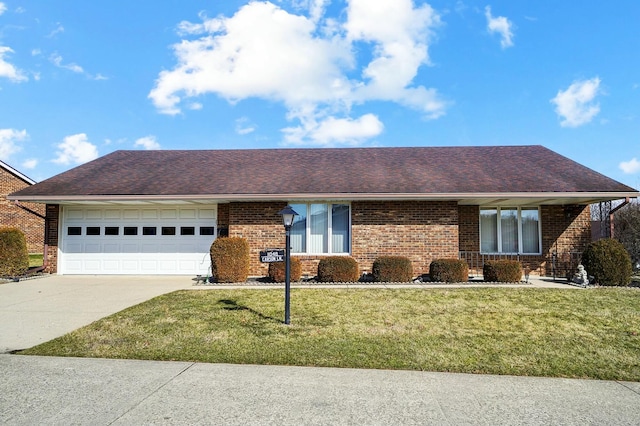 single story home with a garage, concrete driveway, brick siding, and a front lawn