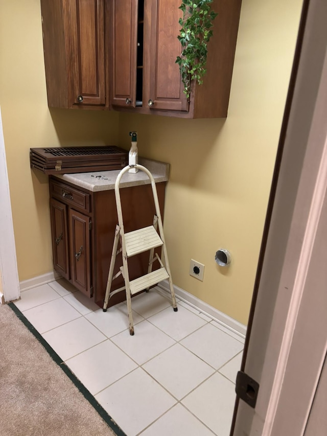 laundry area with light tile patterned floors, electric dryer hookup, and baseboards