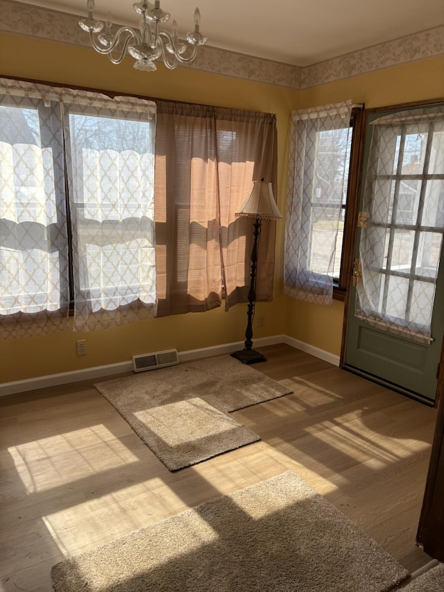 interior space with visible vents, baseboards, and an inviting chandelier