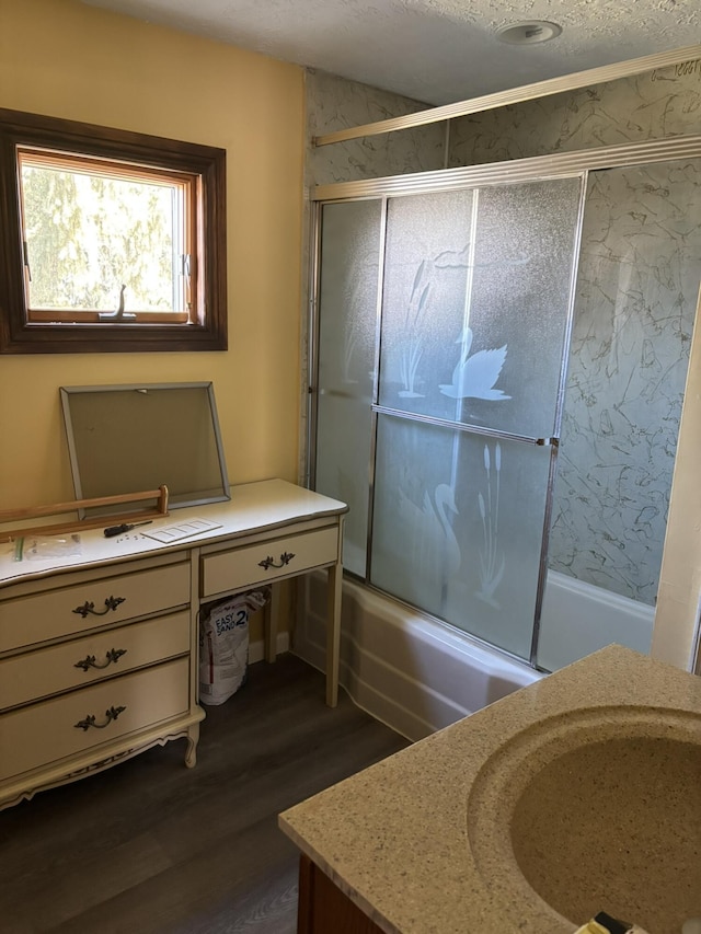 bathroom featuring enclosed tub / shower combo, vanity, and wood finished floors