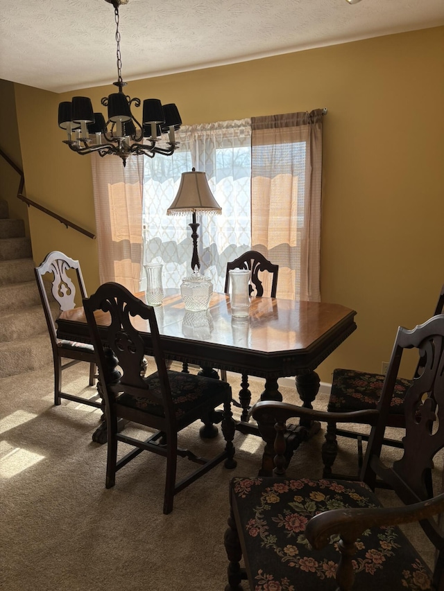 dining room featuring a chandelier, carpet floors, stairway, and a textured ceiling