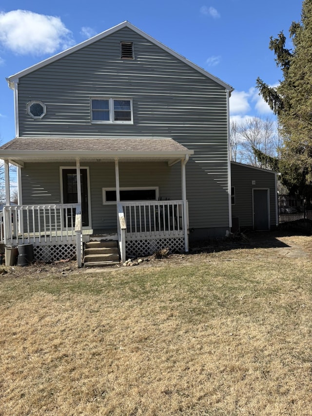 rear view of house with a porch and a yard