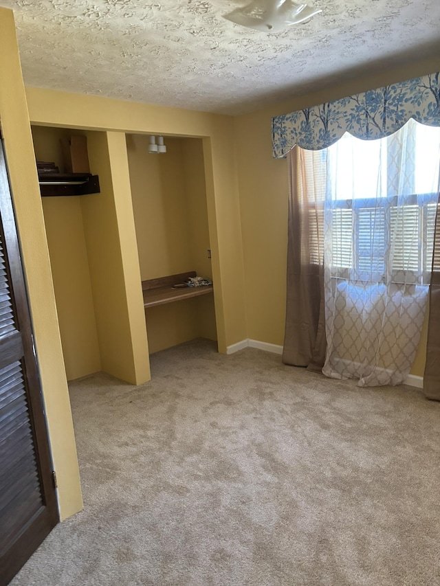 unfurnished bedroom with a textured ceiling, a closet, and carpet