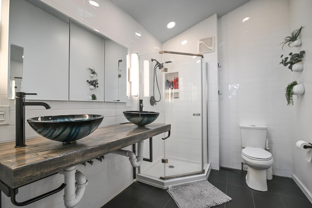 full bath featuring a stall shower, a sink, and tile patterned floors