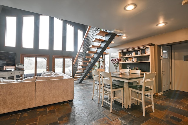 dining room with stone tile floors, stairs, and recessed lighting