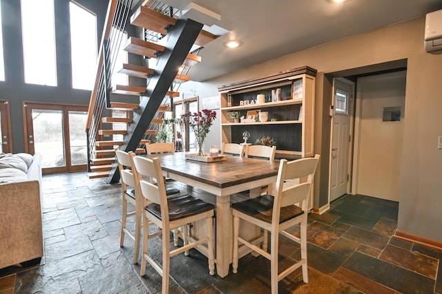 dining room with stone tile flooring, baseboards, stairway, and french doors