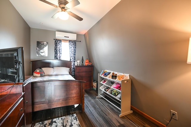 bedroom with dark wood-style flooring, a wall mounted air conditioner, ceiling fan, and baseboards