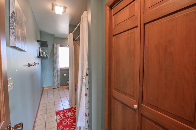 interior space with baseboards and light tile patterned floors