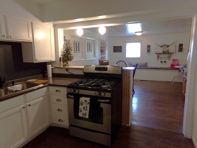 88 E Clark St, North Hampton, OH 45349 - kitchen with gas stove, dark wood finished floors, a peninsula, dark countertops, and white cabinetry